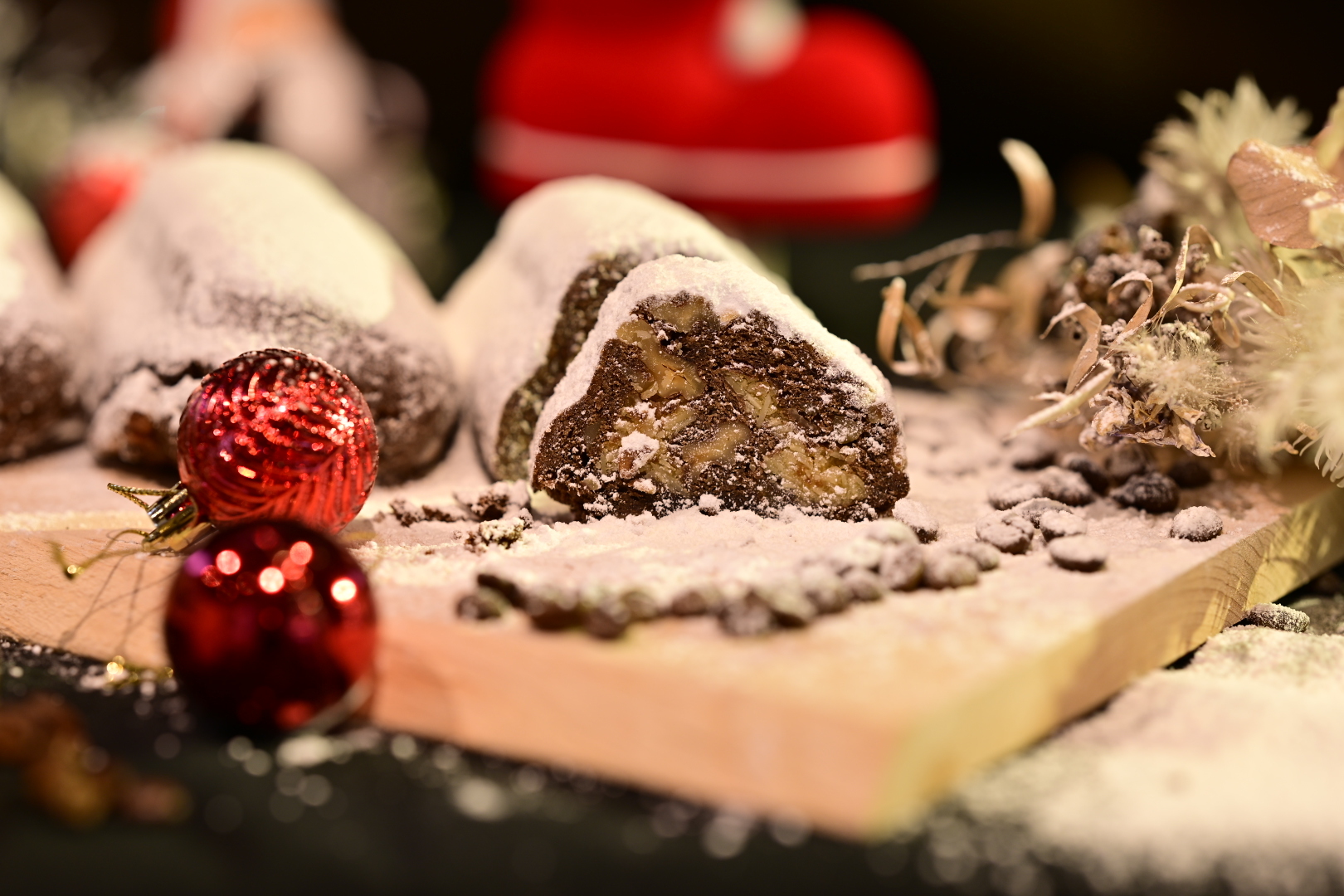 粉糖のかかったシュトーレンの断面とコーヒー、赤いオーナメント